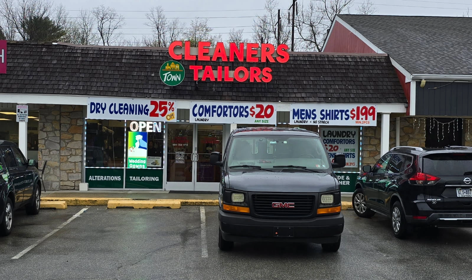 Storefront of Town Cleaners & Tailors in Downingtown, PA, featuring promotional signage for dry cleaning, shirt laundering, and tailoring services.